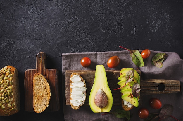 Sommige geroosterd met groene avocado op zwart beton