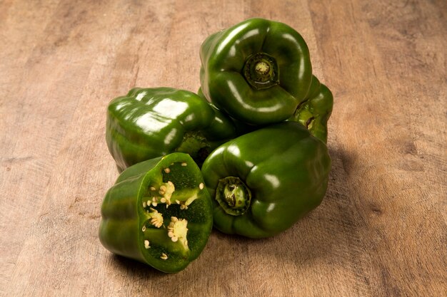 Sommige groene paprika's op een houten oppervlak. Verse groente.