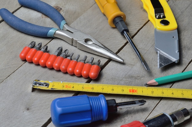 Sommige huisreparatietools liggen op een houten ondergrond. detailopname.