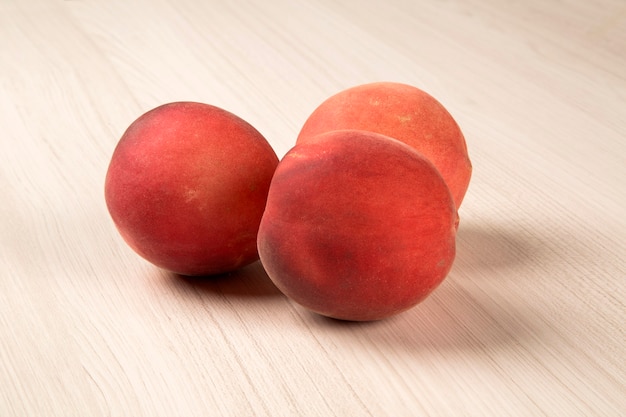 Sommige perziken in een mand op een houten oppervlak. Vers fruit