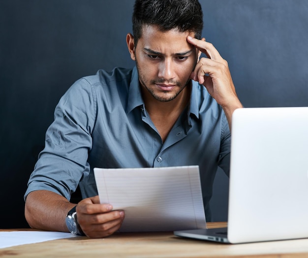 Sommige uitdagingen zijn meer een strijd dan andere Bijgesneden opname van een knappe jonge zakenman die er gestrest uitziet terwijl hij aan zijn bureau werkt