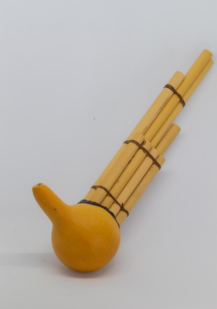 Foto sompoton een van de traditionele muziekinstrumenten van borneo op de tafel tegen een witte achtergrond