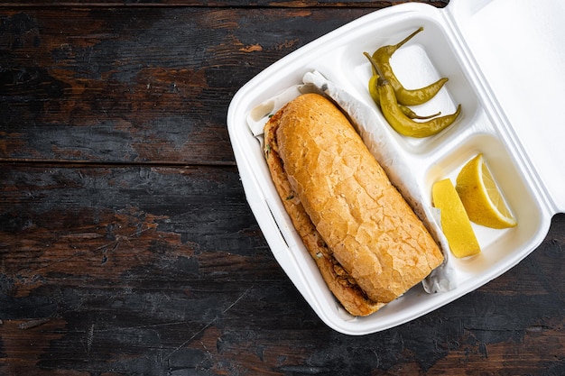 Foto somun ekmek tavuk tantuni kip turkse kebab in plastic verpakking container levering lunchbox op oude donkere houten tafel achtergrond bovenaanzicht plat lag met kopie ruimte voor tekst