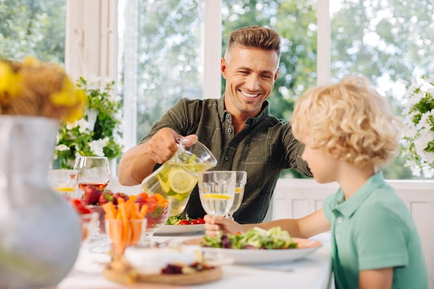 外で昼食をとりながらレモネードを求める息子