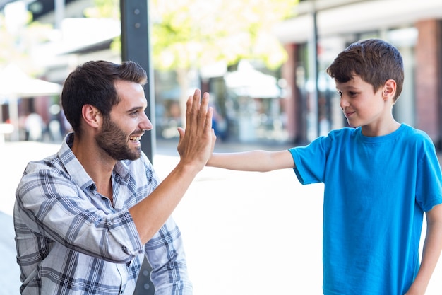 Son and father doing high five 