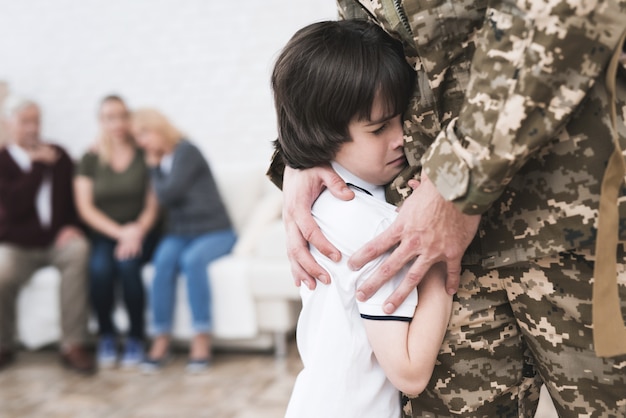 Il figlio abbraccia papà che va all'esercito.