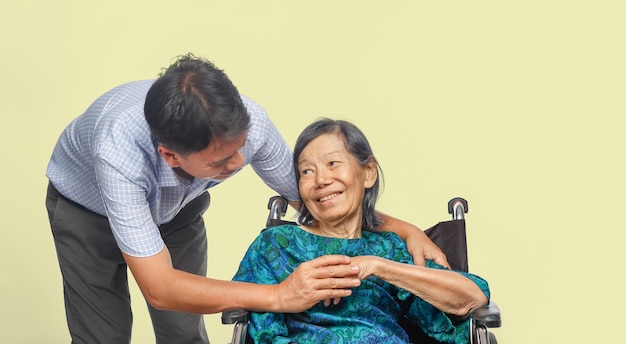 車椅子で年配の母親の世話をしている息子