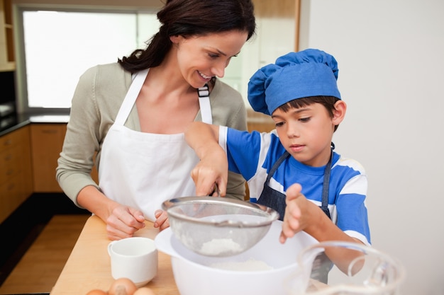 Son and mother preparing dough