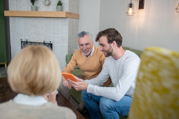 Son visiting parents and showing new photos to them