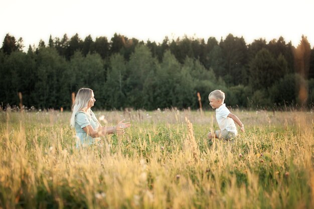 Photo son with his mother in the summer walks in the field