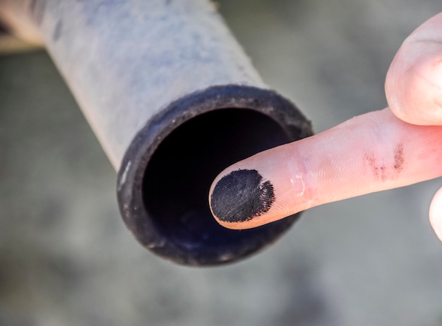 Photo soot from the exhaust pipe on the finger examination of the car's exhaust system by the automaker