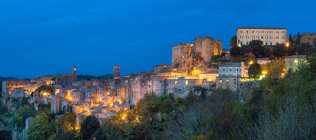 Sorano - tufsteenstad in Toscane. Italië. Uitzicht in de schemering met verlichting, reisachtergrond