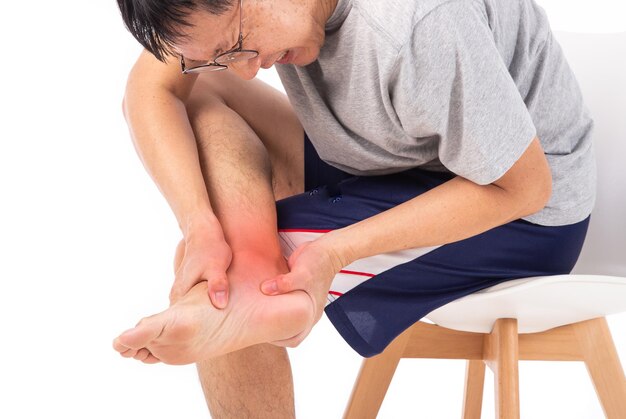 Sore pain of ankle Sprain and arthritis symptoms middle age man holding his hurt ankle