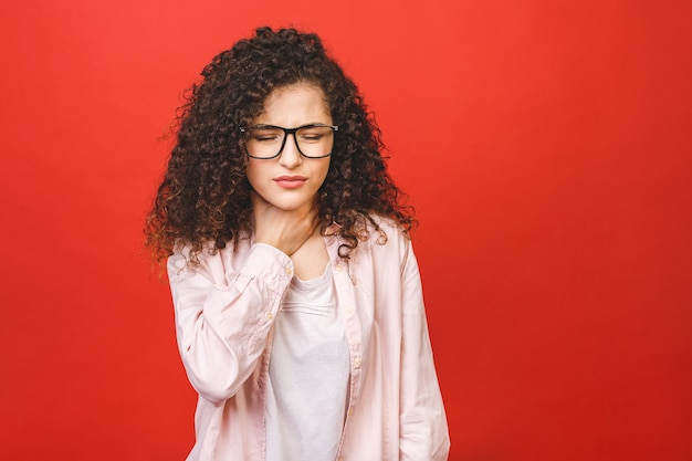 女性の喉の痛み。首に触れます。赤の背景に分離されました。