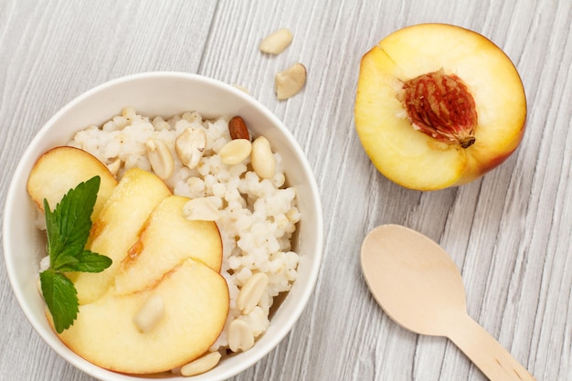 Sorghumsalade met noten en verse perzik op grijze planken