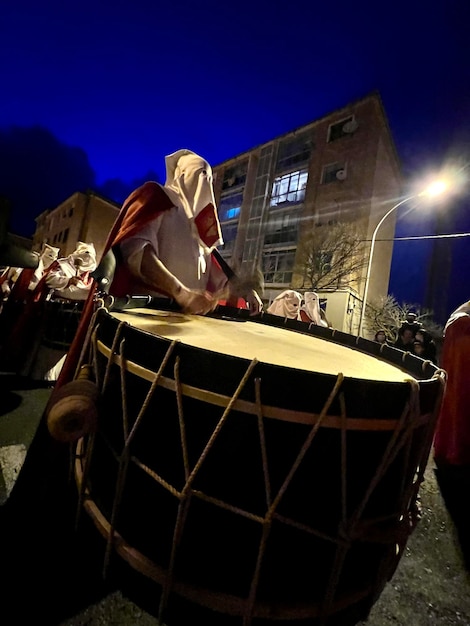 Soria Spain April 11 2022 image of a hooded brother playing the bass drum during the procession on Holy Monday in Holy Week