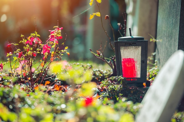 Sorrow concept Red candle in iron lantern at the cemetery funeral