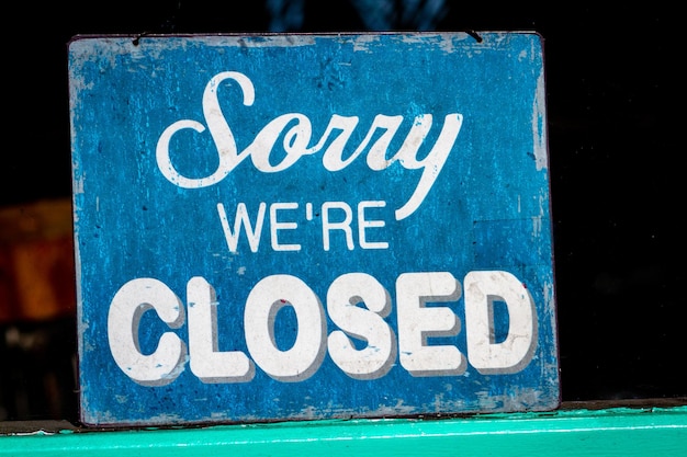 Photo sorry we are closed sign in a shop window