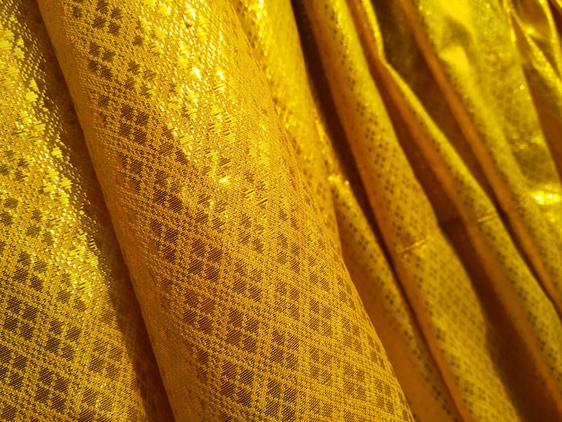 Sorting golden fabric on outdoor with blurred gold background