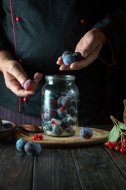 Photo sorting plums by the cook hands cooking sweet jam from fresh plum and sugar on the kitchen table the process of preserving prunus in a jar