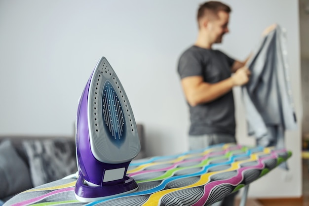 Sorting and stacking clothes after ironing on an ironing board.