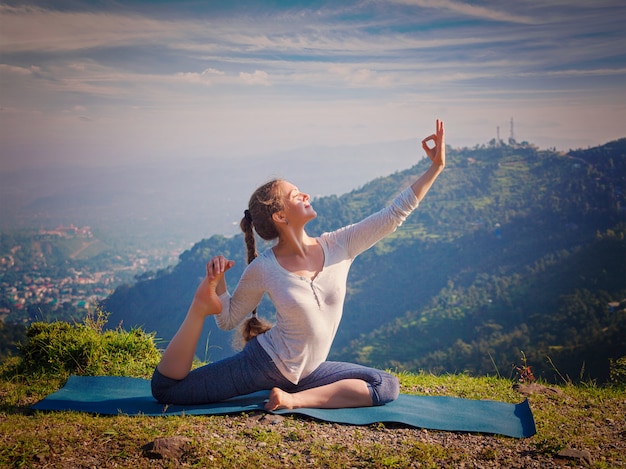 Sorty fit vrouw doet yoga asana buiten in de bergen