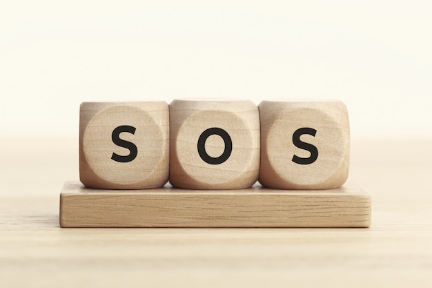 SOS-concept. Houten blok met tekst op tafel.