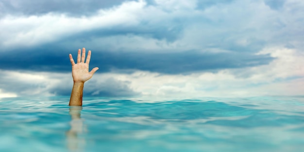 SOS help man drowing hand on blue rippled ocean blue cloudy sky background