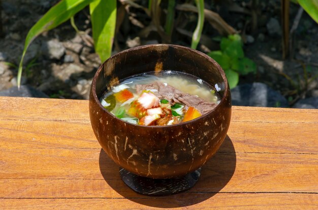 Soto batok een javaanse rundvleessoep geserveerd in een traditionele kom gemaakt van kokosnootschaal