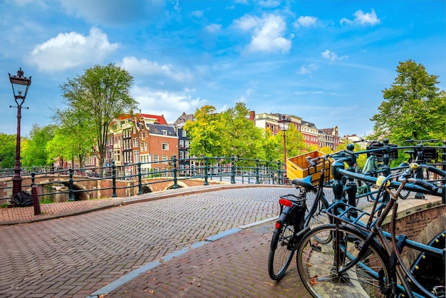 写真 一枚の写真でアムステルダムの魂傾いた家は運河の自転車とランタンを橋渡しアムステルダムの有名な旧市街の眺めアムステルダムオランダヨーロッパ