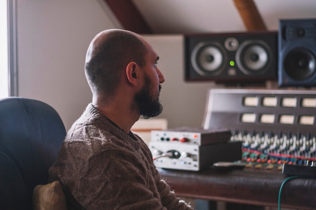 Photo sound engineer sitting in studio