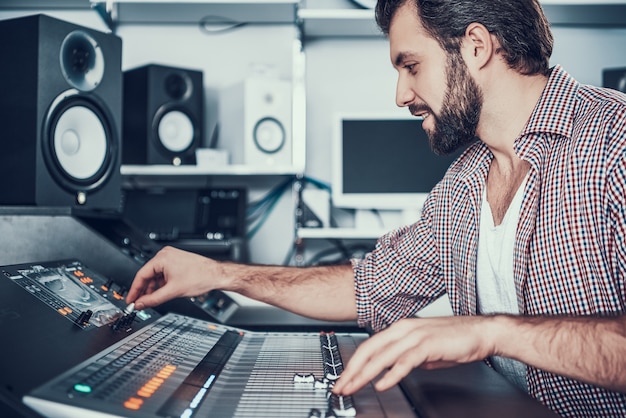 Sound engineer using studio mixing desk.