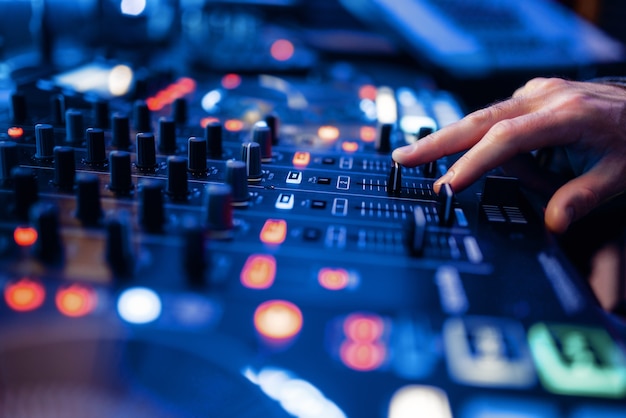 Sound operator hands at the volume control panel in the recording studio.