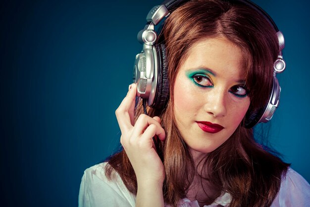 Sound, young girl listening music with huge headphones