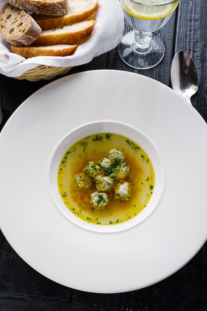 Soup broth with meatballs in a white plate. Concept for a menu in a restaurant