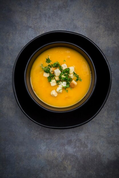 Soup dish of creamed pumpkin soup with croutons and parsley