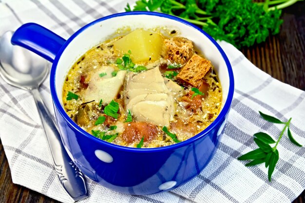 Photo soup fish with vegetables and croutons on dark board