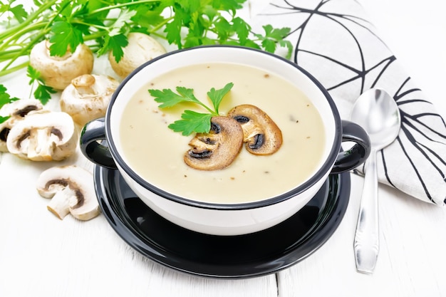 Soup puree of champignon in bowl on board