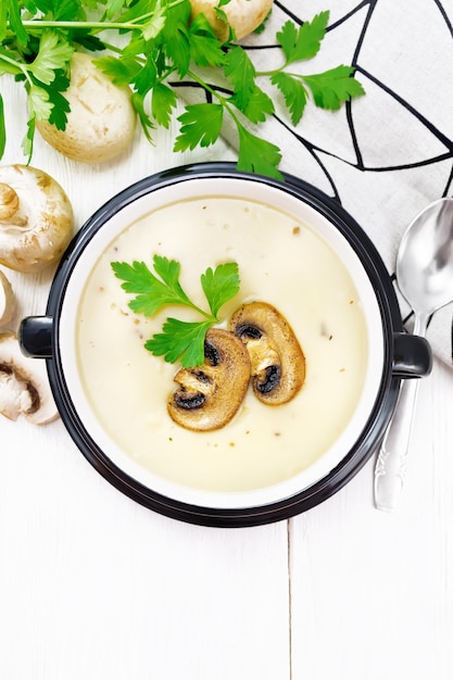 Soup puree of champignon in bowl on table top