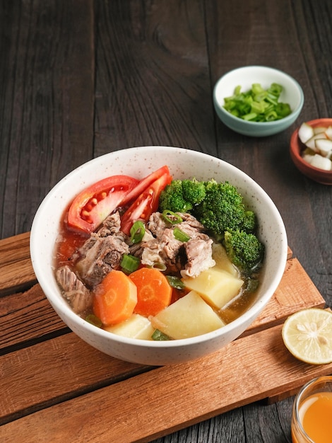 Soup Sop Daging with vegetables is Indonesian traditional food served in bowl Selected focus