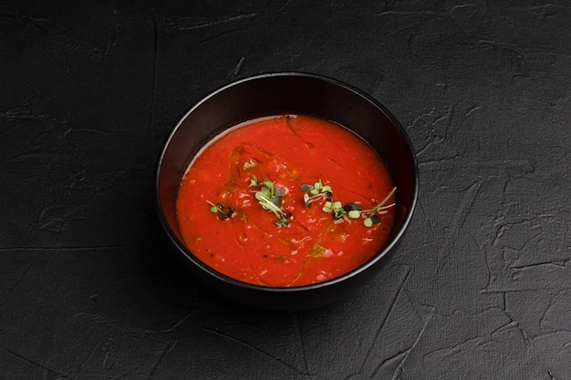 Soup tomato soup on a black background side view