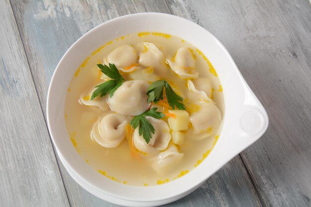 Soup with pelmeni russian dumplings Soup with meat dumplings potatoes and other vegetables