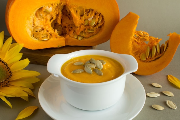 Photo soup with pumpkin  in the white plate on the grey background