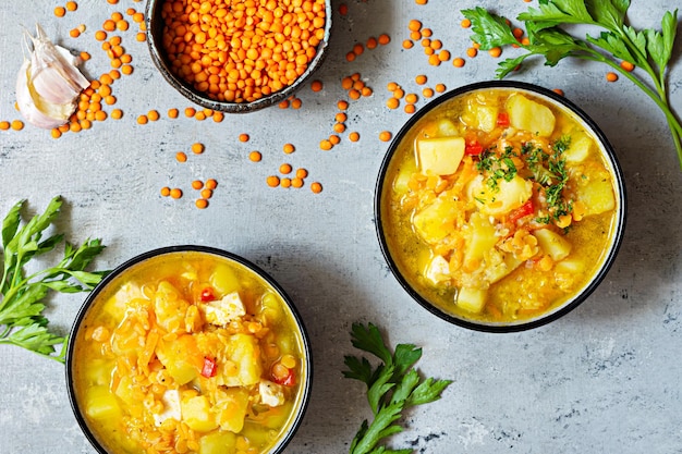 Soup with red lentils and vegetables in a bowl on a blue background.Traditional dish of Turkish