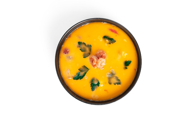 Soup with shrimps in a black deep dish isolated. Thai soup with seafood. Thai tom yum soup.