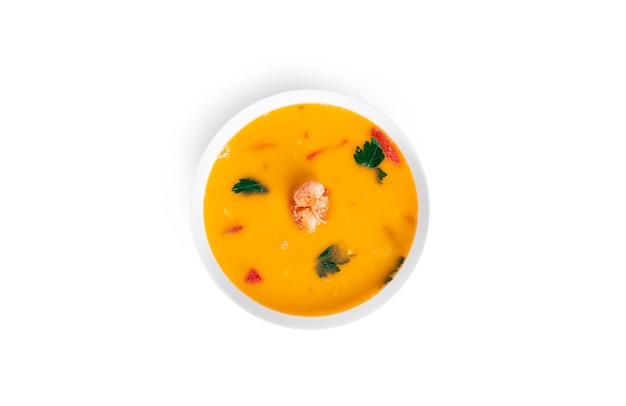 Soup with shrimps in a white deep dish isolated. Thai soup with seafood. Thai tom yum soup.