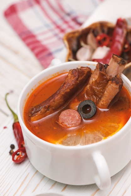 Soup with smoked meat, olives and lemon. Solyanka soup