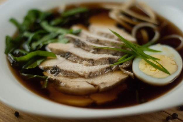 Soup with veal, egg and greens on a wooden stand