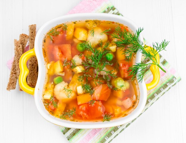 Soup with vegetables green peas and croutons