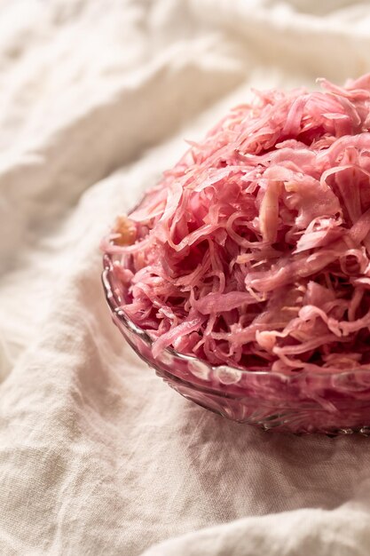 Sour cabbage served in a glass bowl on a rustic tablecloth